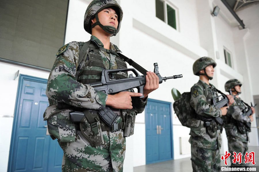 На фото: три военнослужащих НОАК показывают журналистам индивидуальное боевое снаряжение