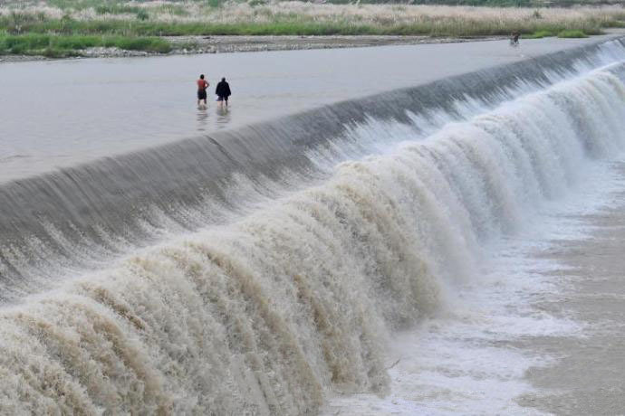 Сельчане в Чэнду пересекают речную плотину (3)