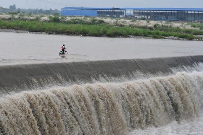 Сельчане в Чэнду пересекают речную плотину (2)