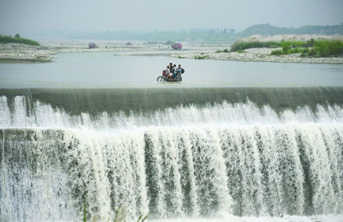 Сельчане в Чэнду пересекают речную плотину