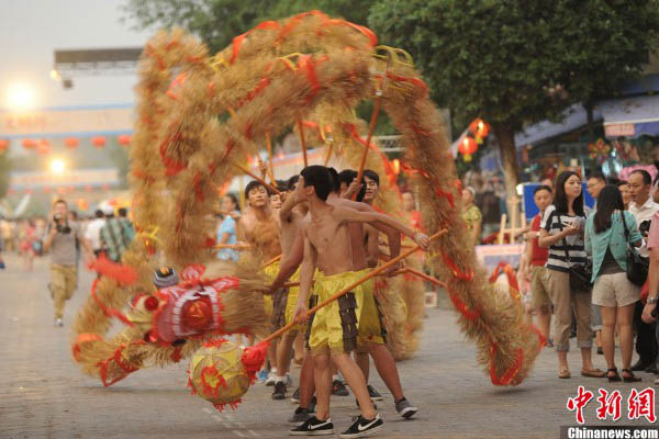 Вечером 17 сентября артисты исполняют танец дракона на улице Янжэньцзе в Чунцине. 