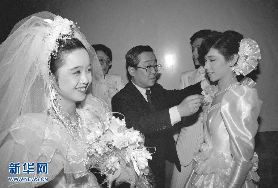 6 февраля 1988 года менеджер совместной китайско-японской свадебной фотогалереи наряжает невест в свадебные платья для участия в коллективной свадьбе.