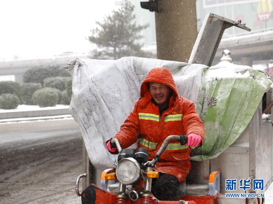 Дворник города Чжэнчжоу ведет мусорную машину. 
