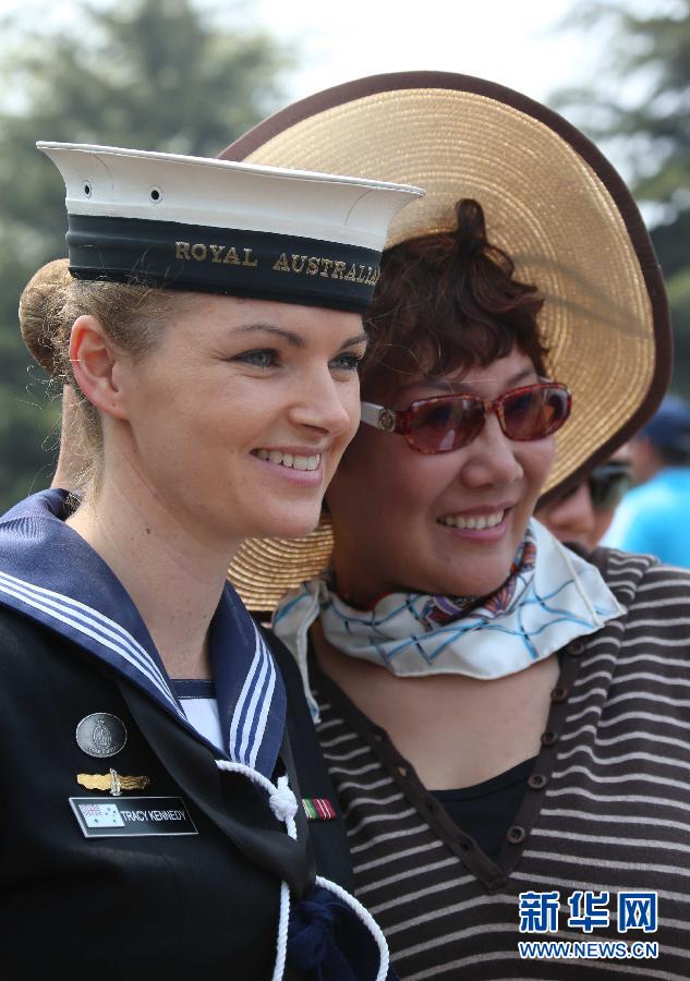 Музыкантша из военного оркестра ВМФ Австралии фотографируется с посетителем.